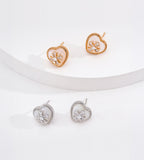 Vintage Gold heart studs on a raised white display with silver-tone studs below, showing mother-of-pearl hearts and sparkling flower details.