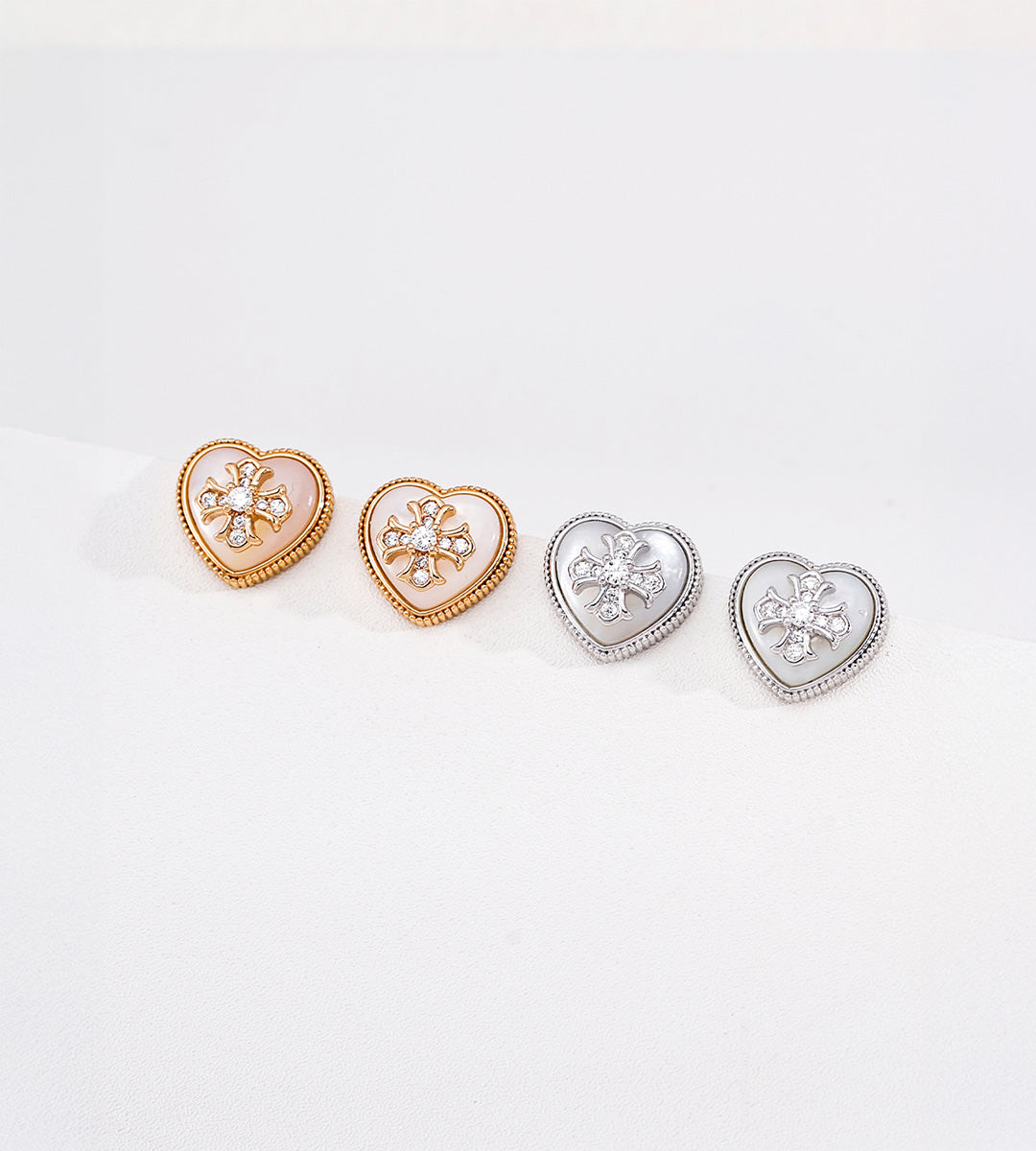 Gold-tone and silver-tone heart stud earrings with mother-of-pearl inlays, cubic zirconia flower accents and beaded borders.