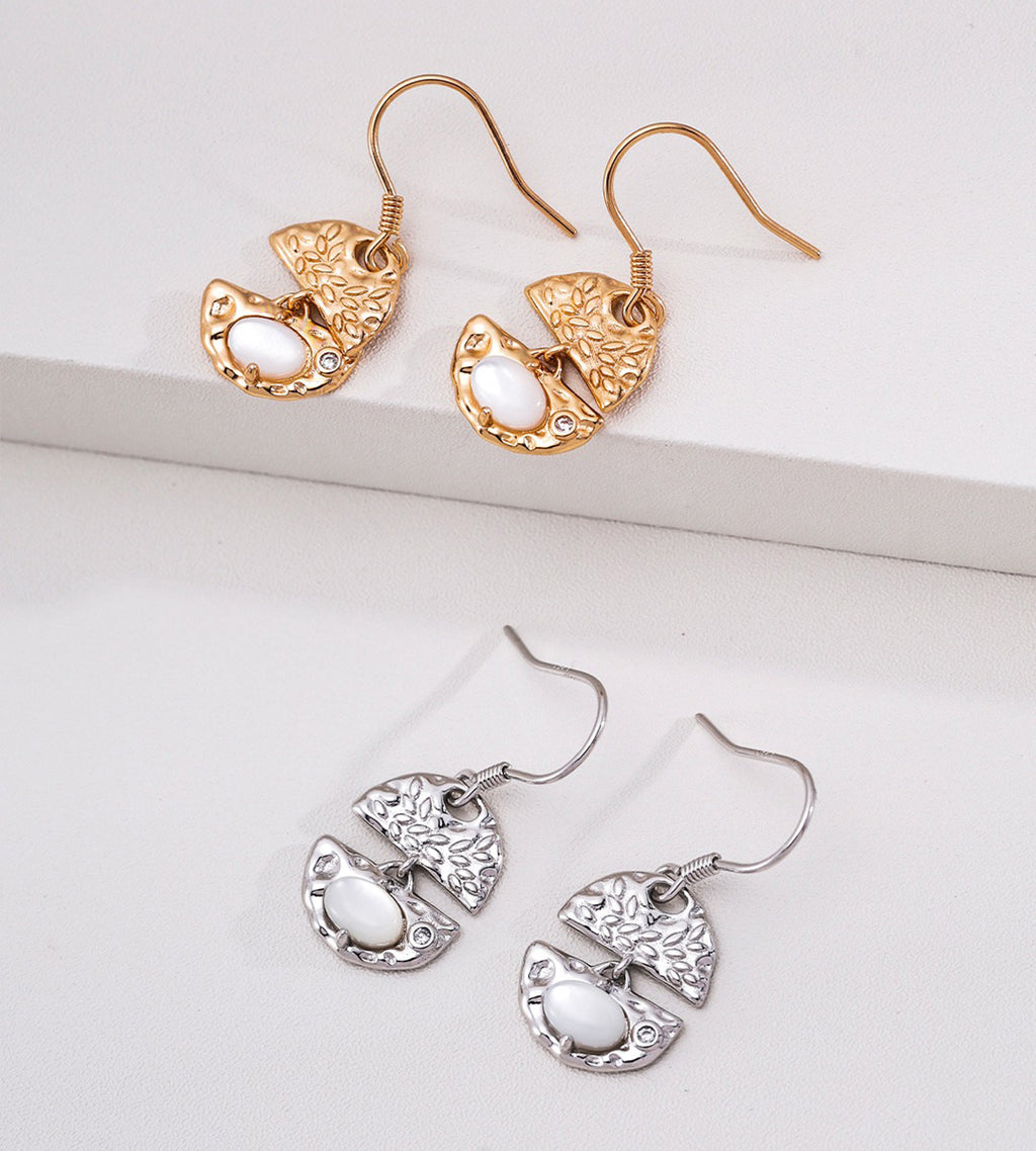 Two pairs of dangling earrings are displayed on a white surface: one pair in 18K gold-plated S925 Silver and one pair in 18K white-gold-plated S925 Silver | BUCKLE Collective