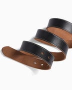 A close-up of a Extended Length leather belt with a black outer strap and a brown suede-like underside, featuring white contrast stitching and metal eyelets, arranged in a spiral on a white background.