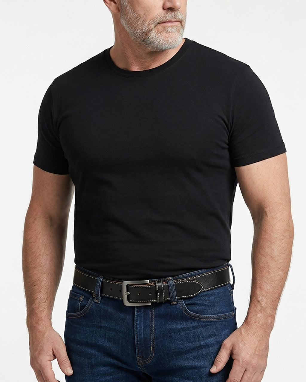 A man wearing a plain black short-sleeve crewneck t-shirt tucked into dark blue jeans with an extended-length genuine leather black belt | BUCKLE Collective