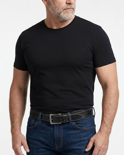 A man wearing a plain black short-sleeve crewneck t-shirt tucked into dark blue jeans with an extended-length genuine leather black belt | BUCKLE Collective