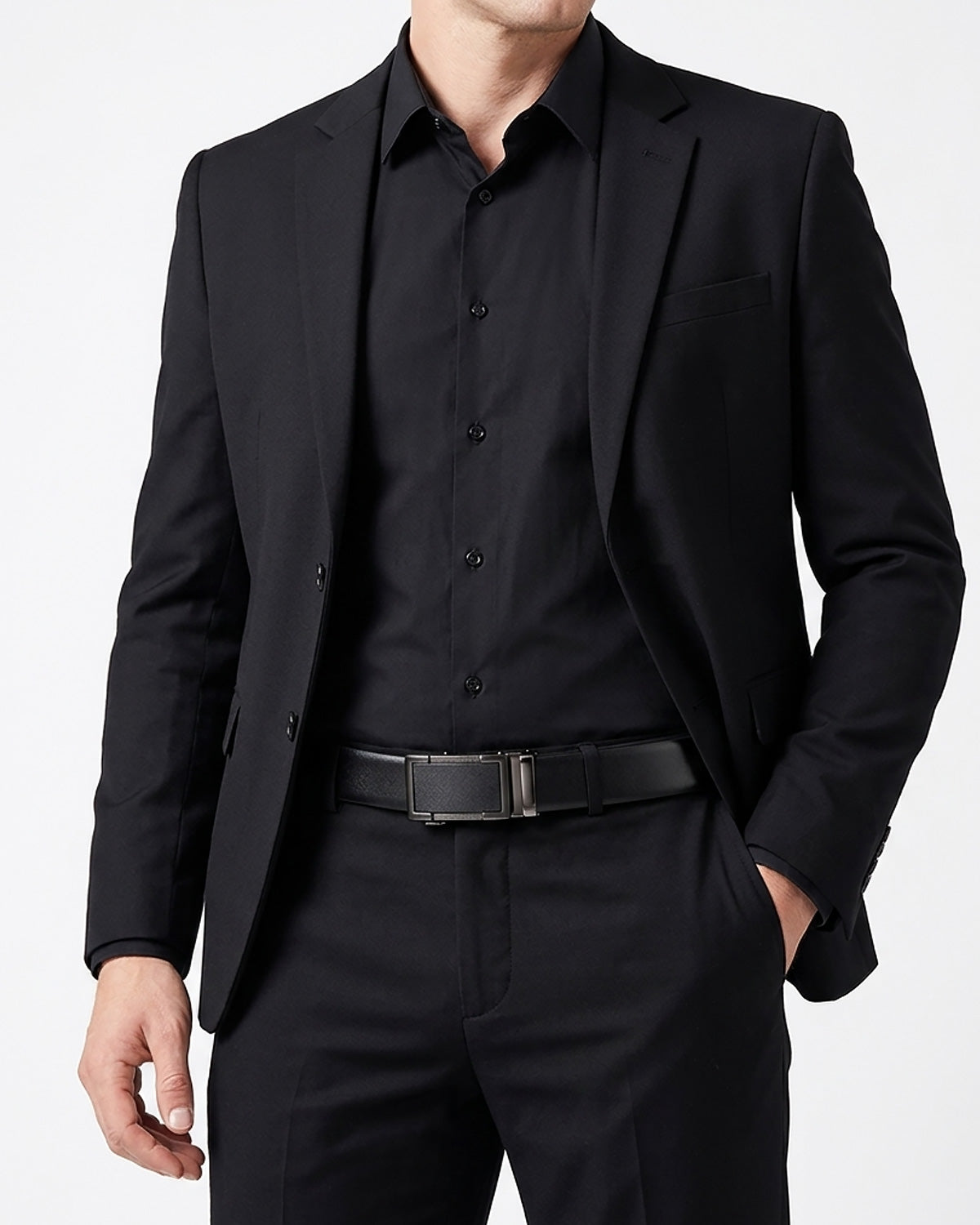 A man wearing a black suit jacket, black dress shirt, black trousers, and a black belt with a black buckle by BUCKLE Collective