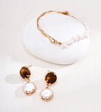 A jewelry set with 18K Gold Plated S925 Silver Adjustable Minimalist Freshwater Pearl Slider Bracelet and a Tiger-Eye and Mother-of-Pearl Earrings