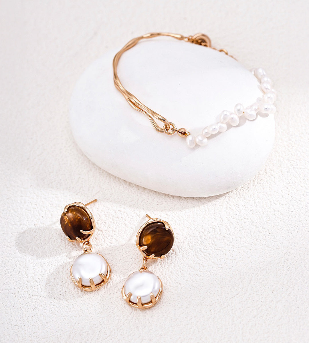 A jewelry set with 18K Gold Plated S925 Silver Adjustable Minimalist Freshwater Pearl Slider Bracelet and a Tiger-Eye and Mother-of-Pearl Earrings
