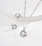 Flower natural pearl pendant necklace in silver-tone styled with matching floral pearl stud earrings — sculpted floral frame, 6mm natural pearl, beaded satellite chain, 18K white gold plated S925 silver, BUCKLE Collective