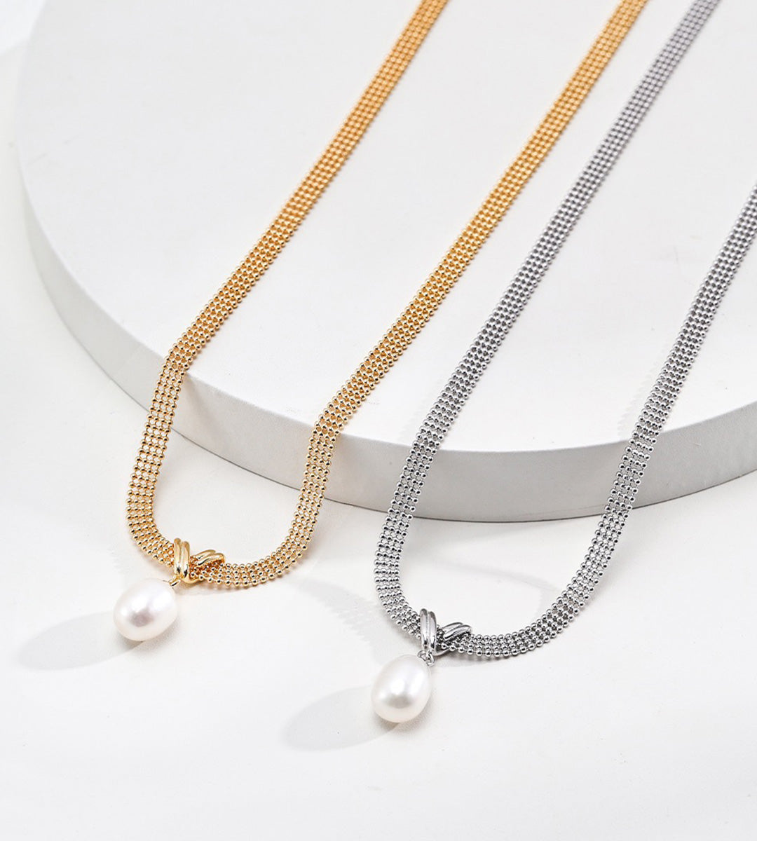 A pair of a Natural Pearl Mesh Chain Choker Necklaces placed next to each other