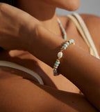 Natural Pearl Shoushan stone bracelet worn on wrist — sky-blue stone beads, freshwater pearl centre, and gold spacer accents, 18K gold plated S925 sterling silver, boho coastal style, BUCKLE Collective