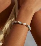 Natural Pearl Shoushan stone bracelet worn on wrist — sky-blue stone beads, freshwater pearl centre, and gold spacer accents, 18K gold plated S925 sterling silver, boho coastal style, BUCKLE Collective