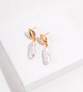 Angled view of 18K gold-plated S925 silver baroque pearl drop earrings, showing fluid-shaped tops and ear posts.