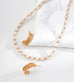 18K gold-plated and white pearl jewelry set featuring a delicate necklace and matching earrings, displayed on a soft white fabric background.