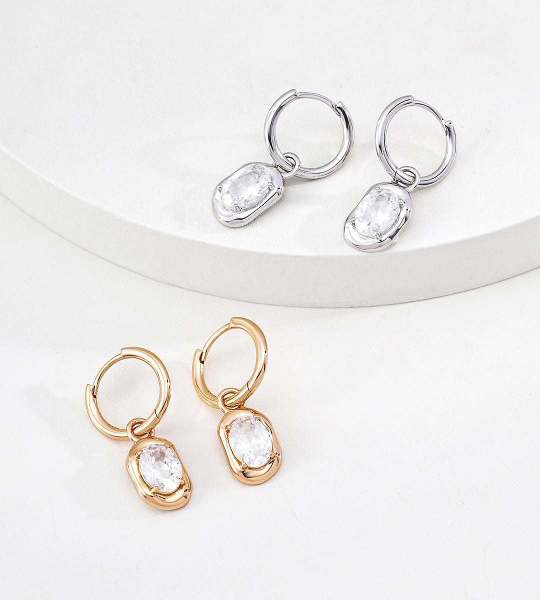 Two pairs of 18K gold-plated S925 silver hoop earrings with oval zirconia stones, shown in silver and gold tones on a clean white background.