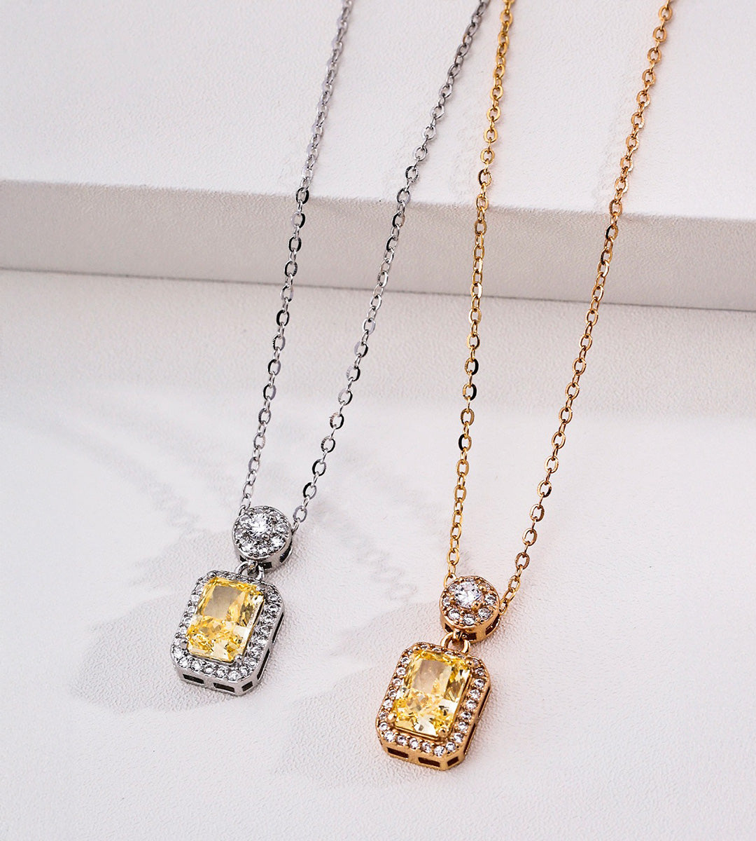 A pair of 18K Gold-Plated S2925 Sterling Silver Rectangular Yellow Cubic Zirconia Pendant Necklaces placed next to each other