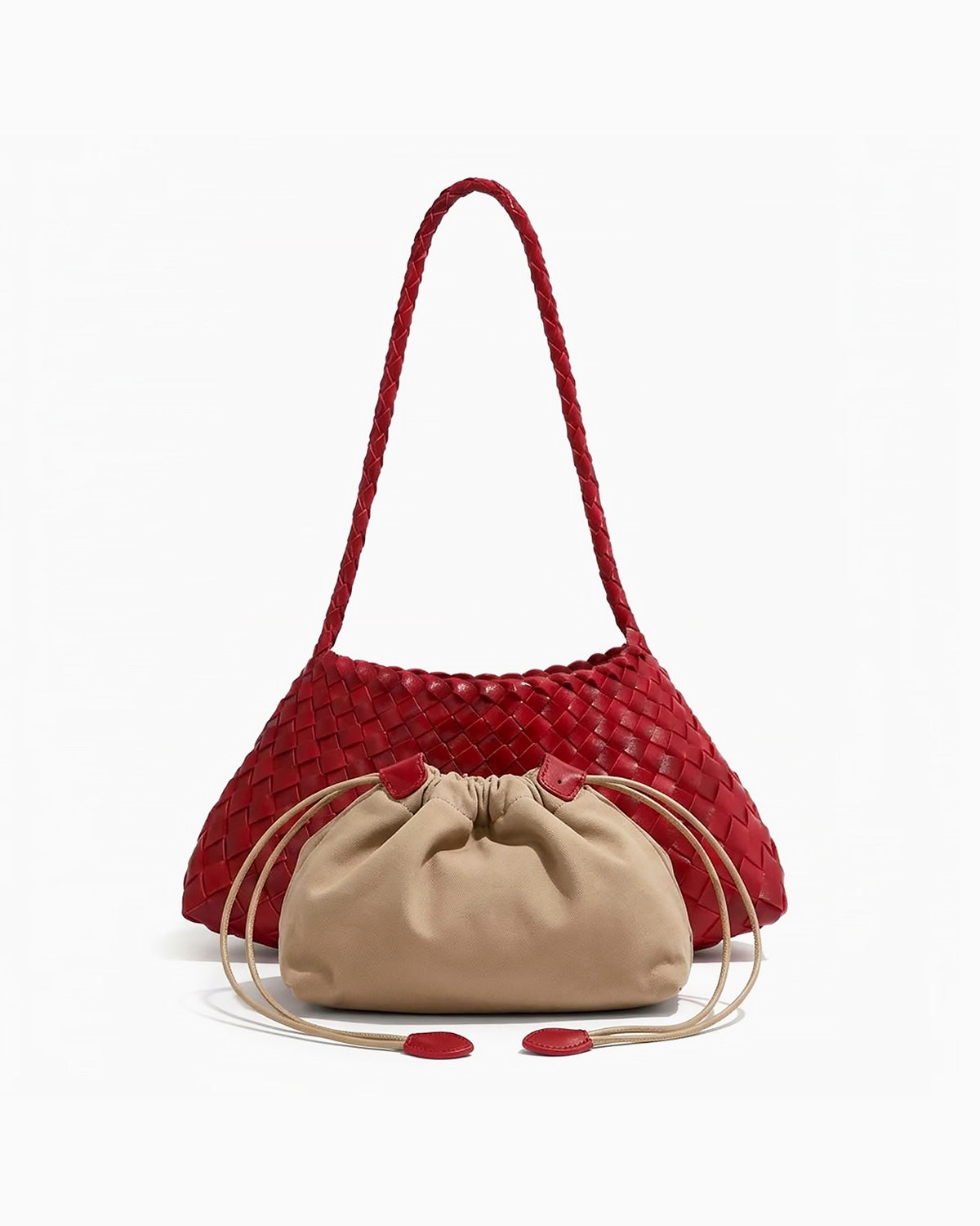 A red woven leather shoulder bag with a braided strap, paired with a beige drawstring pouch in front of it on a clean white background.