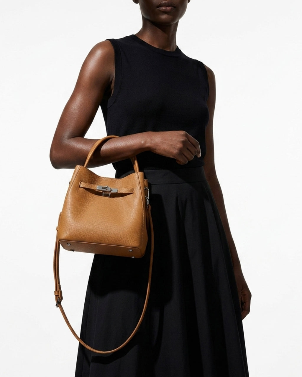 Stylish woman in a fashionable black outfit with a Classic Genuine Leather Bucket Bag in Walnut Color with Detachable Strap & Pouch 