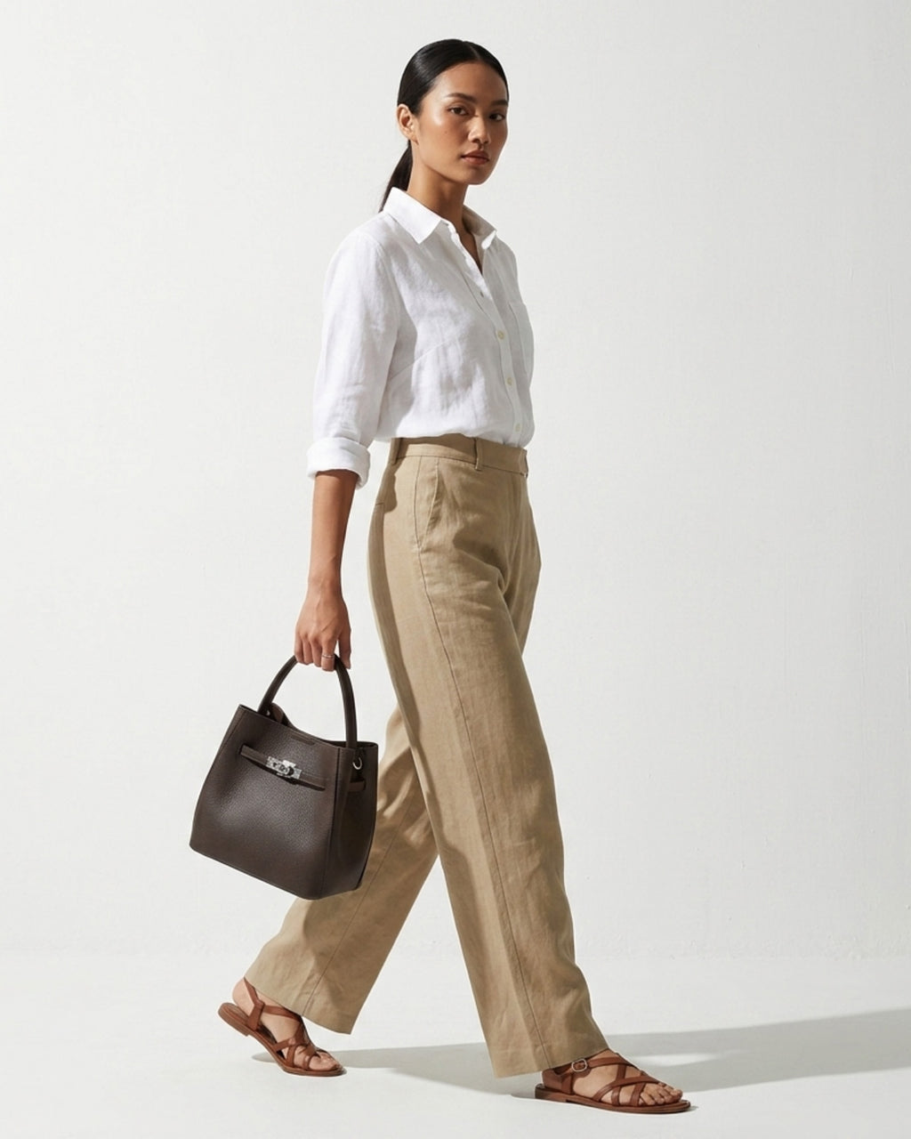 Woman in a stylish casual outfit with Classic Genuine Leather Bucket Bag with Detachable Strap & Pouch in Coffee Color