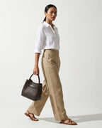 Woman in a stylish casual outfit with Classic Genuine Leather Bucket Bag with Detachable Strap & Pouch in Coffee Color