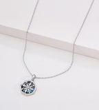Abalone shell star compass necklace in white gold plating — eight-pointed compass motif with iridescent shell inlay, wavy octagonal border, adjustable cable chain, S925 sterling silver, BUCKLE Collective