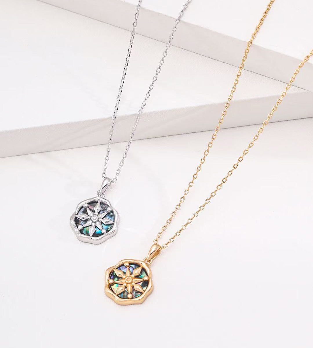 Abalone shell star compass necklace in white gold plating and vintage gold plating — both colourways, eight-pointed compass pendant with iridescent shell inlay, wavy octagonal border, S925 sterling silver, BUCKLE Collective