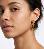 A close-up of a woman's ear wearing 18K Gold-Plated S925 Silver Teardrop Tiger's Eye Drop Earrings | BUCKLE Collective
