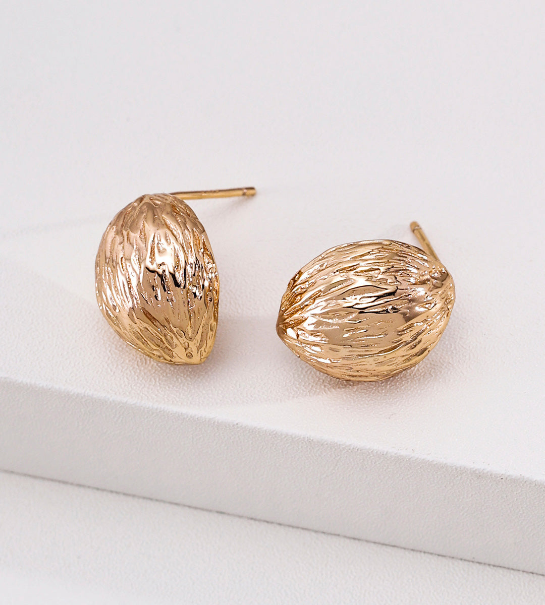 A pair of textured 18K gold-plated S925 silver dome stud earrings with a hammered, organic surface finish, displayed on a clean white surface.