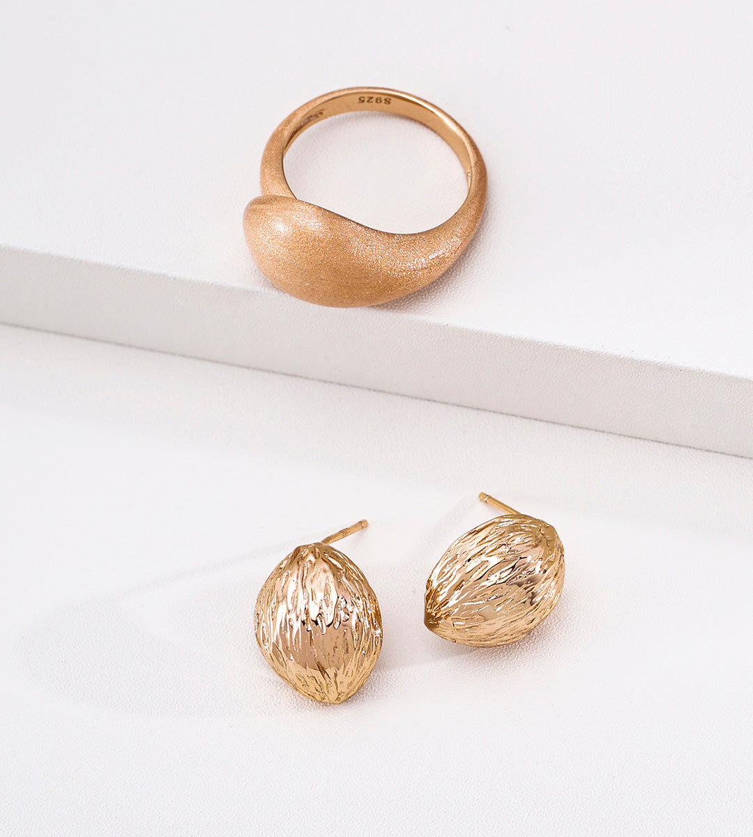 A gold ring and matching textured 18K gold-plated S925 silver dome stud earrings with a hammered, organic surface finish, displayed on a clean white surface.