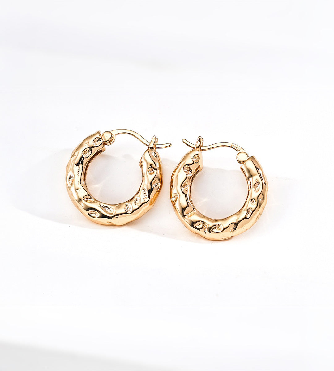 A pair of textured 18K gold-plated S925 silver hoop earrings with a hammered finish, displayed on a clean white background.