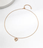 Rock textured heart pendant necklace flatlay in vintage gold — delicate cable chain with lobster clasp and 6cm extender, pavé CZ heart pendant approx. 1.5cm, 18K gold plated S925 sterling silver, BUCKLE Collective