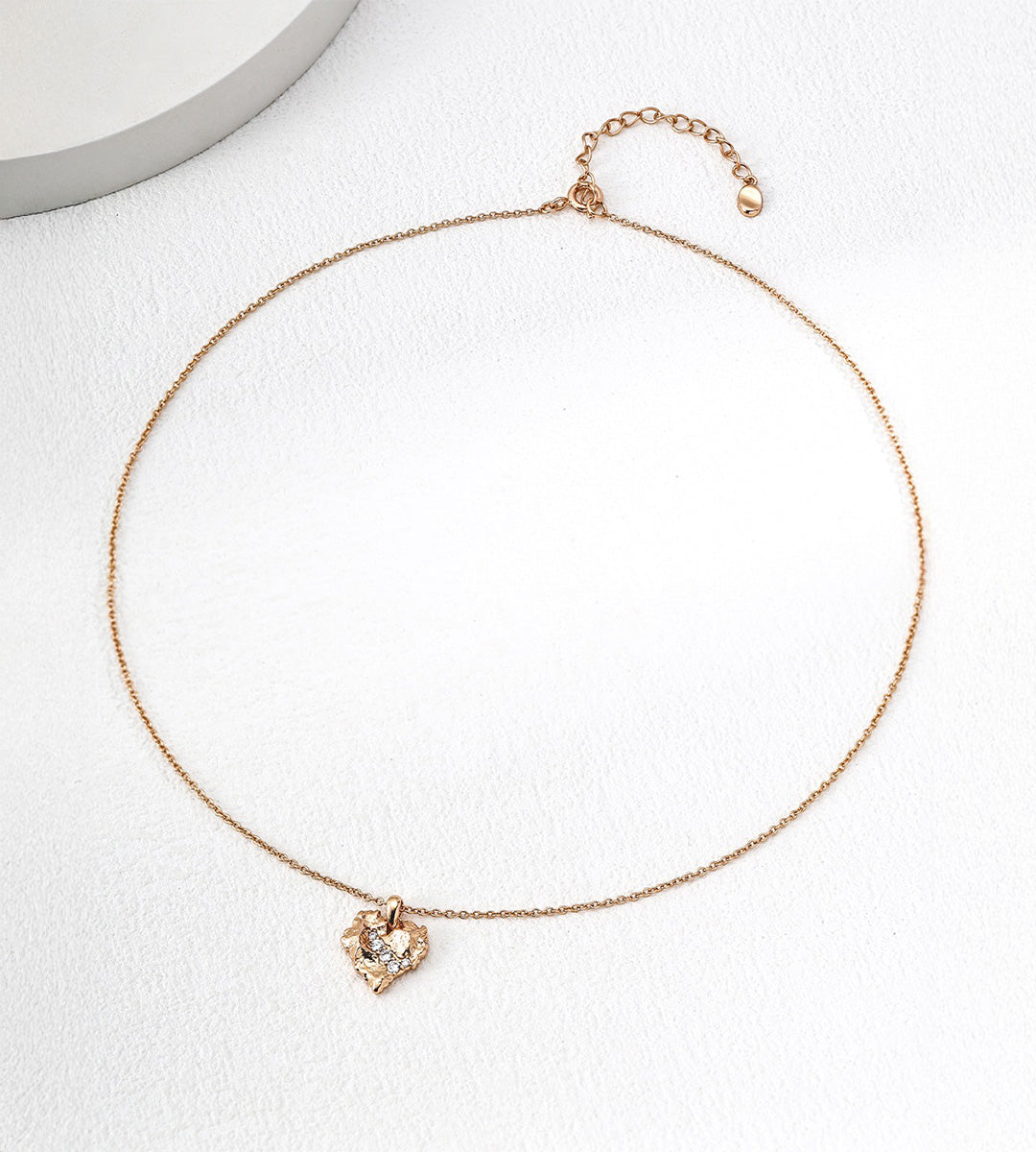 Rock textured heart pendant necklace flatlay in vintage gold — delicate cable chain with lobster clasp and 6cm extender, pavé CZ heart pendant approx. 1.5cm, 18K gold plated S925 sterling silver, BUCKLE Collective
