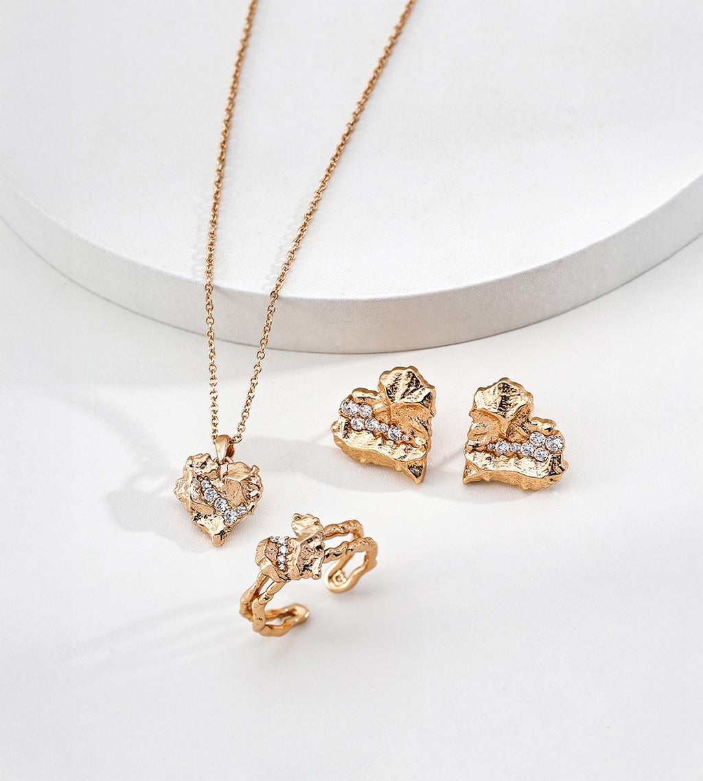 Textured rock heart stud earrings overhead view — irregular cracked gold surface with pavé cubic zirconia stones, 18K gold plated S925 sterling silver, vintage gold, BUCKLE Collective

