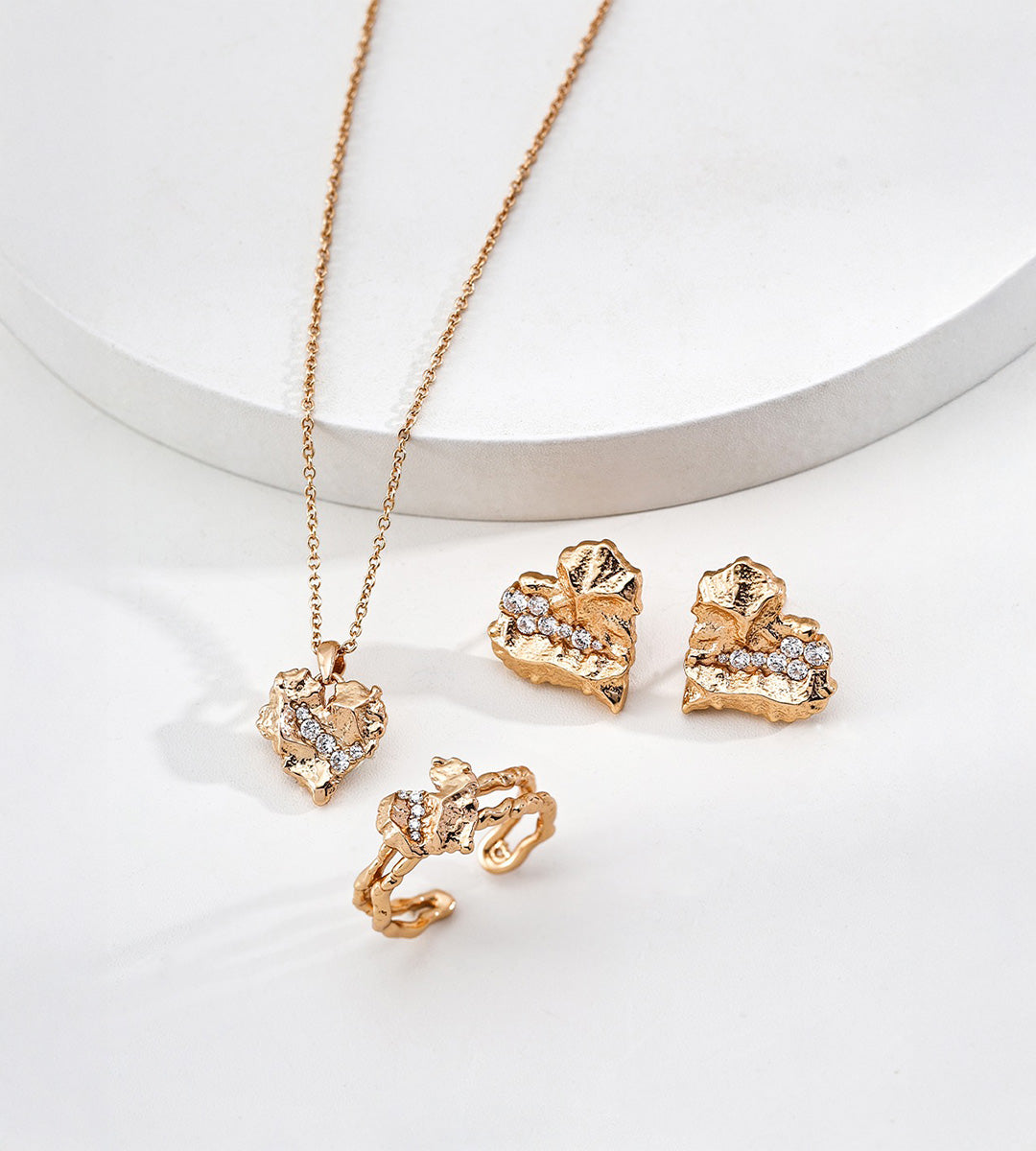 Textured rock heart stud earrings overhead view — irregular cracked gold surface with pavé cubic zirconia stones, 18K gold plated S925 sterling silver, vintage gold, BUCKLE Collective

