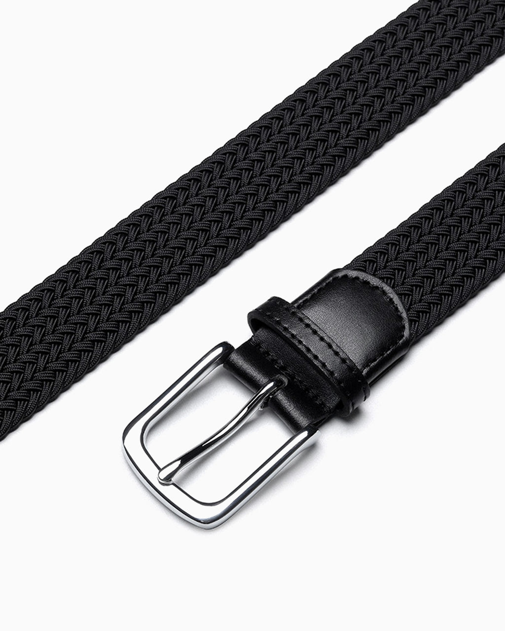 A close-up of a black braided woven belt with a silver metal buckle and a black leather keeper loop by BUCKLE Collective
