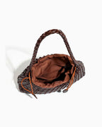 A dark brown woven leather handbag with a braided top handle, shown from an overhead angle to showcase the inner pouch with compartments.