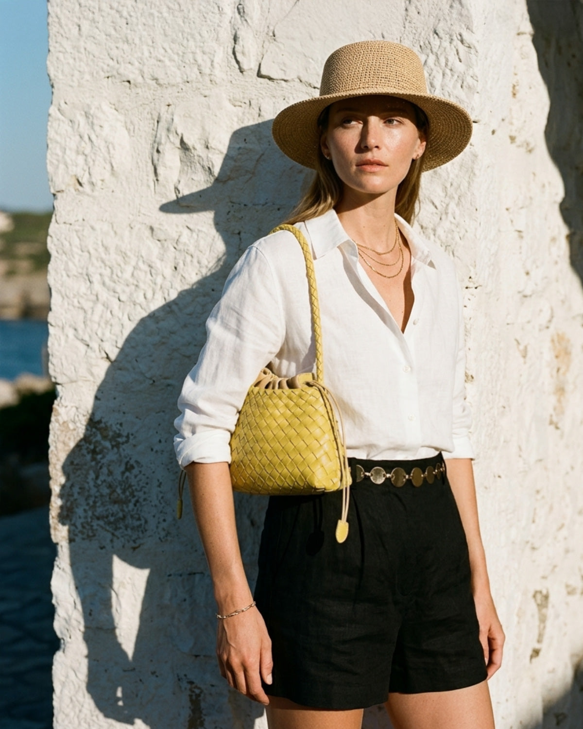 A woman in stylish summer outfit carries a Yellow Vegan Leather Woven Shoulder Bag with Removable Pouch