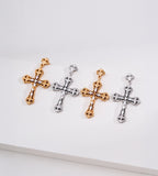 Four ornate cross drop earrings in alternating gold and silver tones, with scrollwork and clear stone accents.