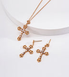 Vintage Gold engraved cross necklace displayed beside matching gold-tone cross drop earrings with sparkling stone accents.