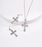White Gold-finish engraved cross necklace displayed beside matching silver-tone cross drop earrings.