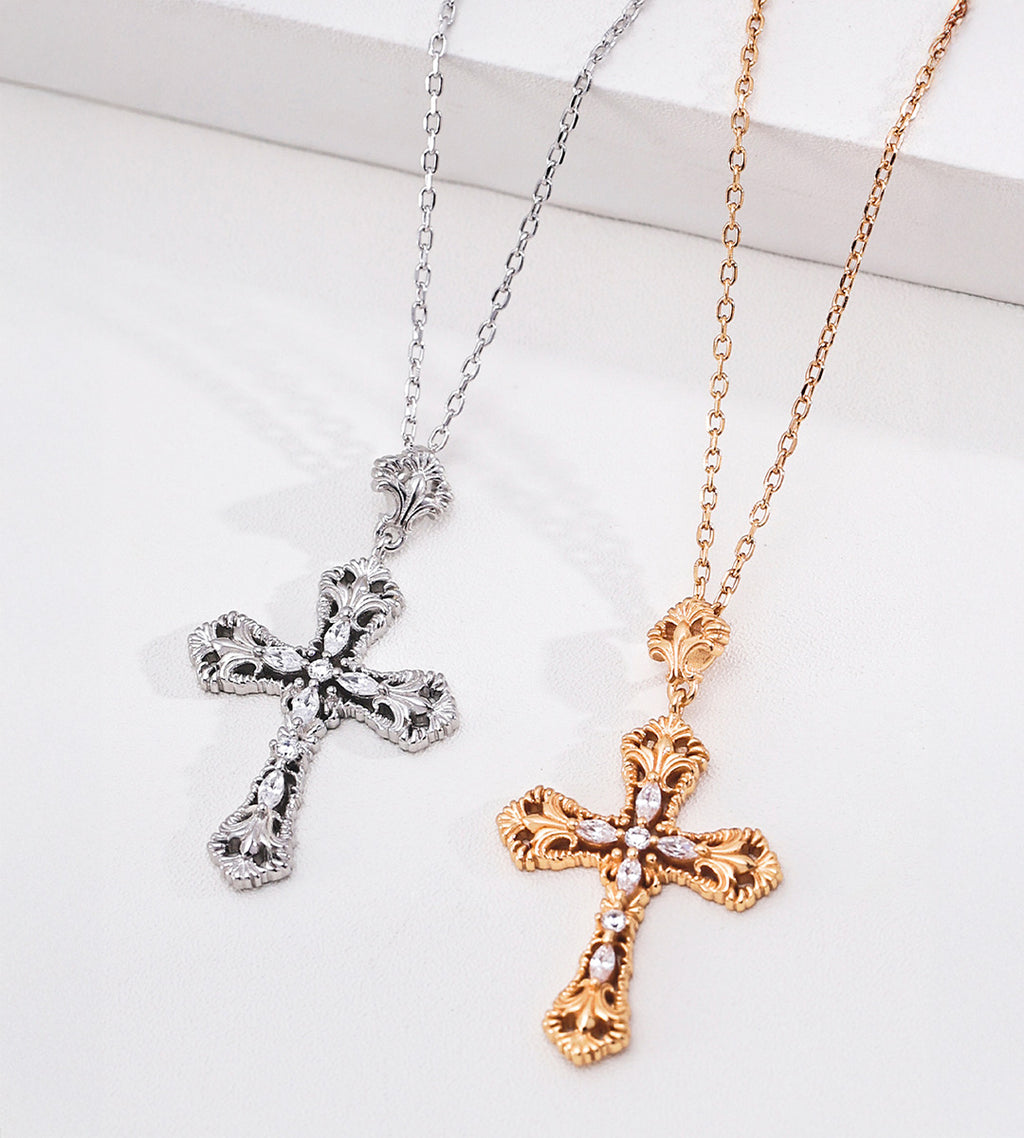 Vintage Gold and White Gold cross necklaces displayed side by side, showing ornate scrollwork and cubic zirconia details.