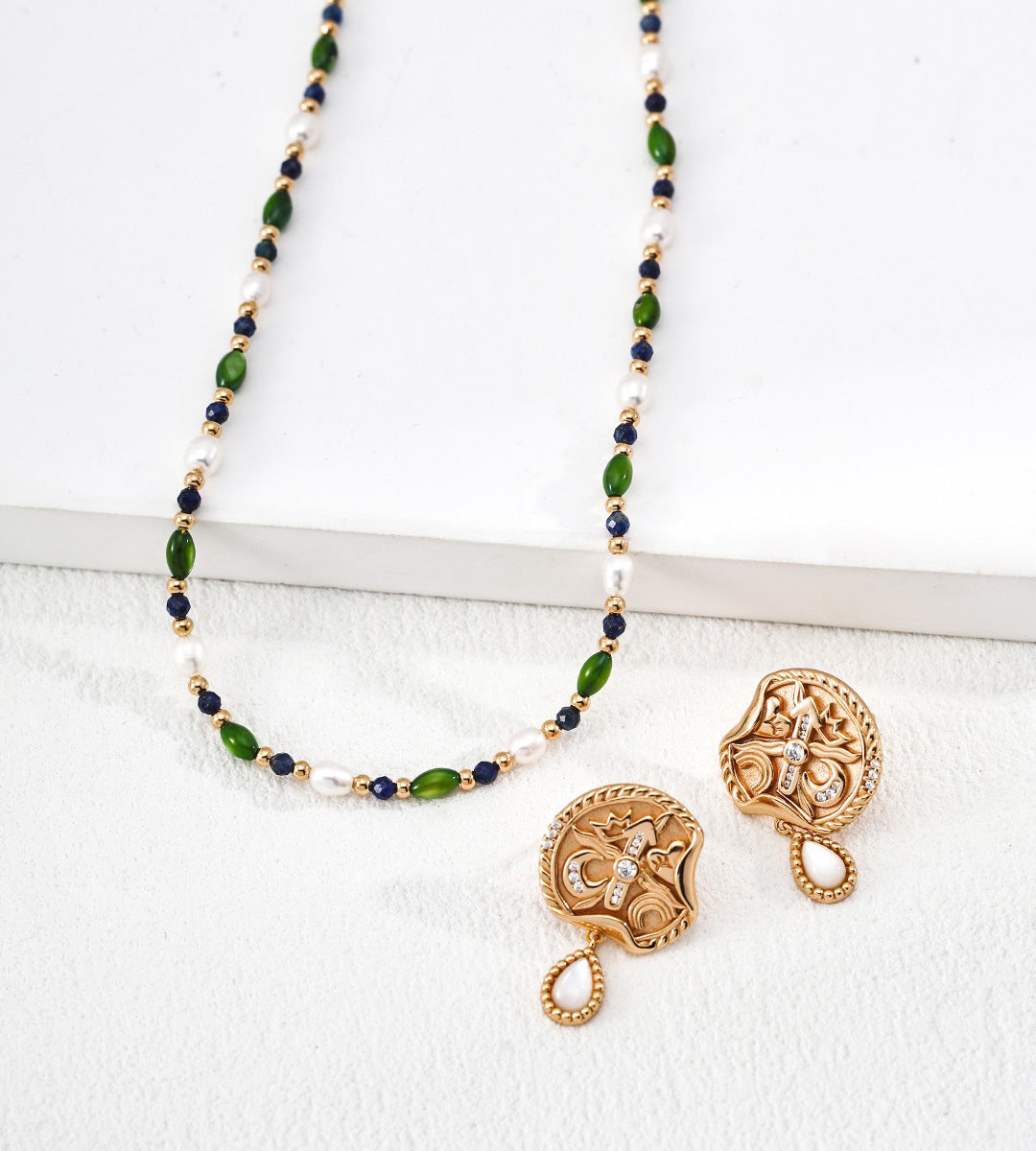 18K gold-plated S925 silver jewelry set featuring a beaded necklace and matching earrings, displayed on a clean white surface. The necklace is composed of alternating green marquise-cut stones, dark navy round beads, and small white pearl-like beads.