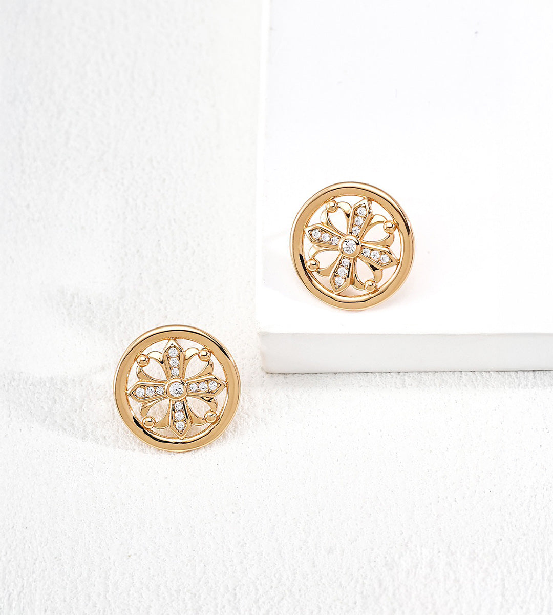 A pair of 18K gold-plated Vintage Iris Cross Stud Earrings with a floral cutout design accented with Zircon
