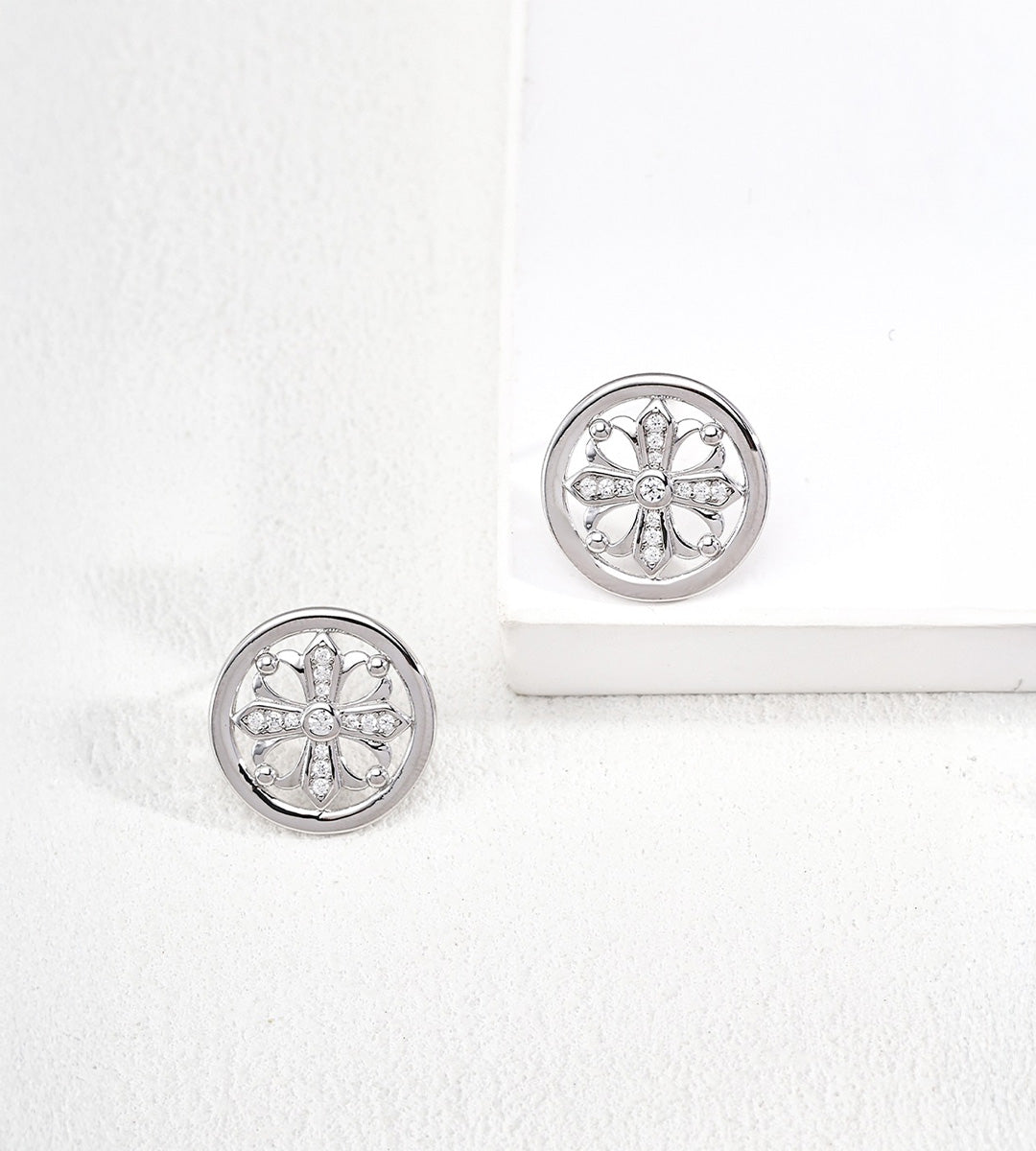 A pair of 18K white-gold-plated Vintage Iris Cross Stud Earrings with a floral cutout design accented with cubic zirconia stones
