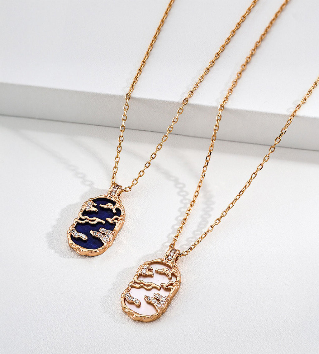 Lapis lazuli and mother-of-pearl landscape necklaces side by side, with gold-tone openwork scenery and cubic zirconia accents