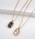 Lapis lazuli and mother-of-pearl landscape necklaces side by side, with gold-tone openwork scenery and cubic zirconia accents
