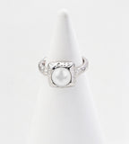 Silver-tone pearl ring with a square hammered-texture frame and matching textured band on a white cone display.