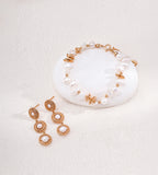Vintage Gold three-tier pearl drop earrings displayed beside a pearl bracelet with gold-tone accents on a white background.