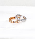 Gold-tone and silver-tone rivet rings overlapping, showing alternating pyramid details, cubic zirconia stones and open adjustable bands.