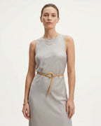 A woman modeling a sleeveless light gray dress with an Apricot Slim Knotted Leather Belt with Gold Loop