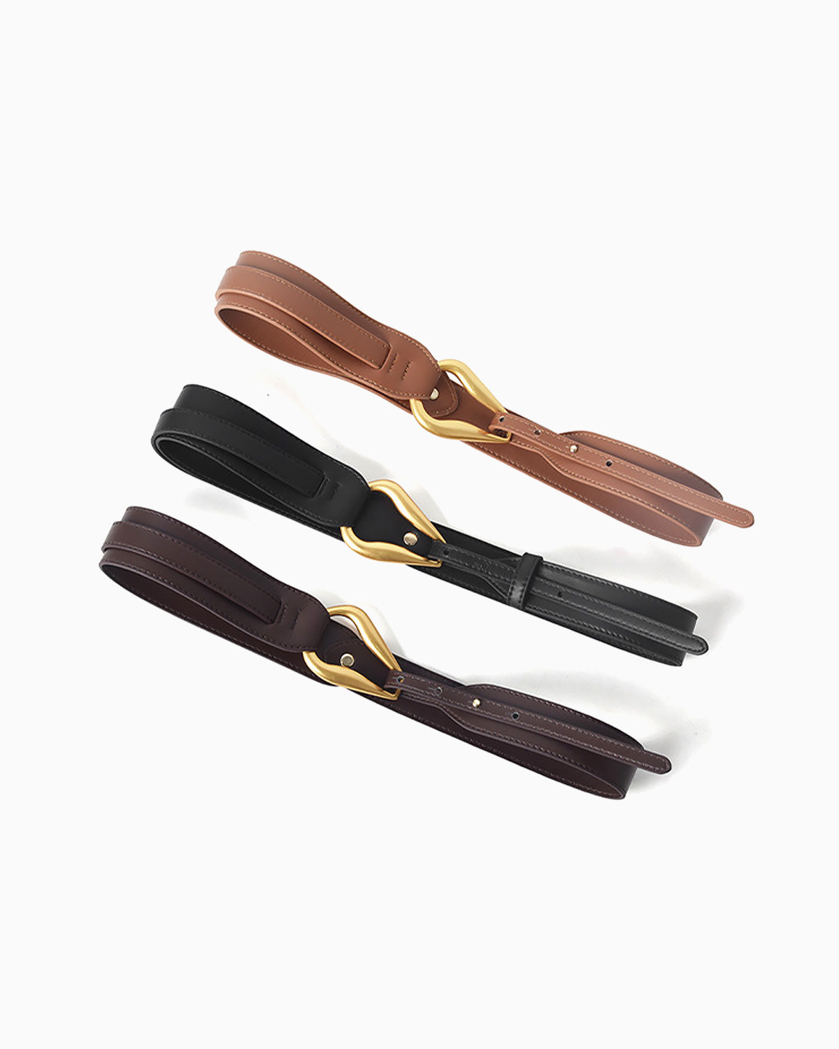 Three leather belts in brown, black, and dark brown, each with a polished gold-tone buckle, arranged diagonally on a clean white background | BUCKLE Collective