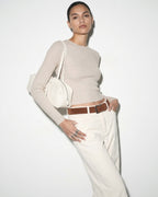 Elegant woman in a stylish casual outfit wearing a Sleek & Spacious Genuine Leather Baguette Shoulder Bag in White Color