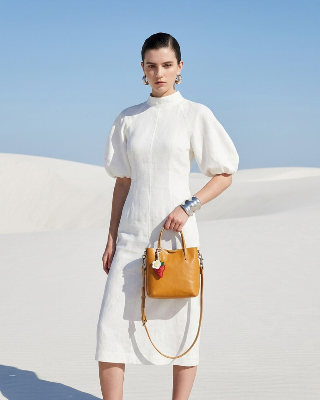 Woman in a white fashion-forward outfit holding a Genuine Leather Yellow Mini Tote Crossbody Bag with Strawberry and Floral Charm